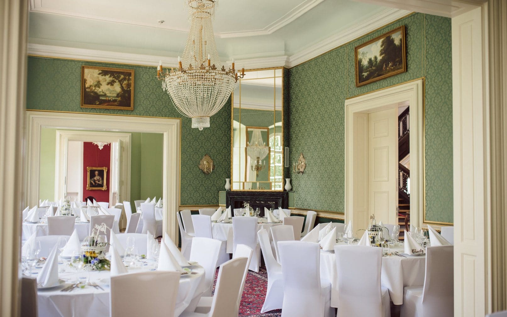 Geschmückter großer Salon aus anderer Perspektive. Blick auf Kronleuchter, Spiegelwand und Blick auf die Eingangstür