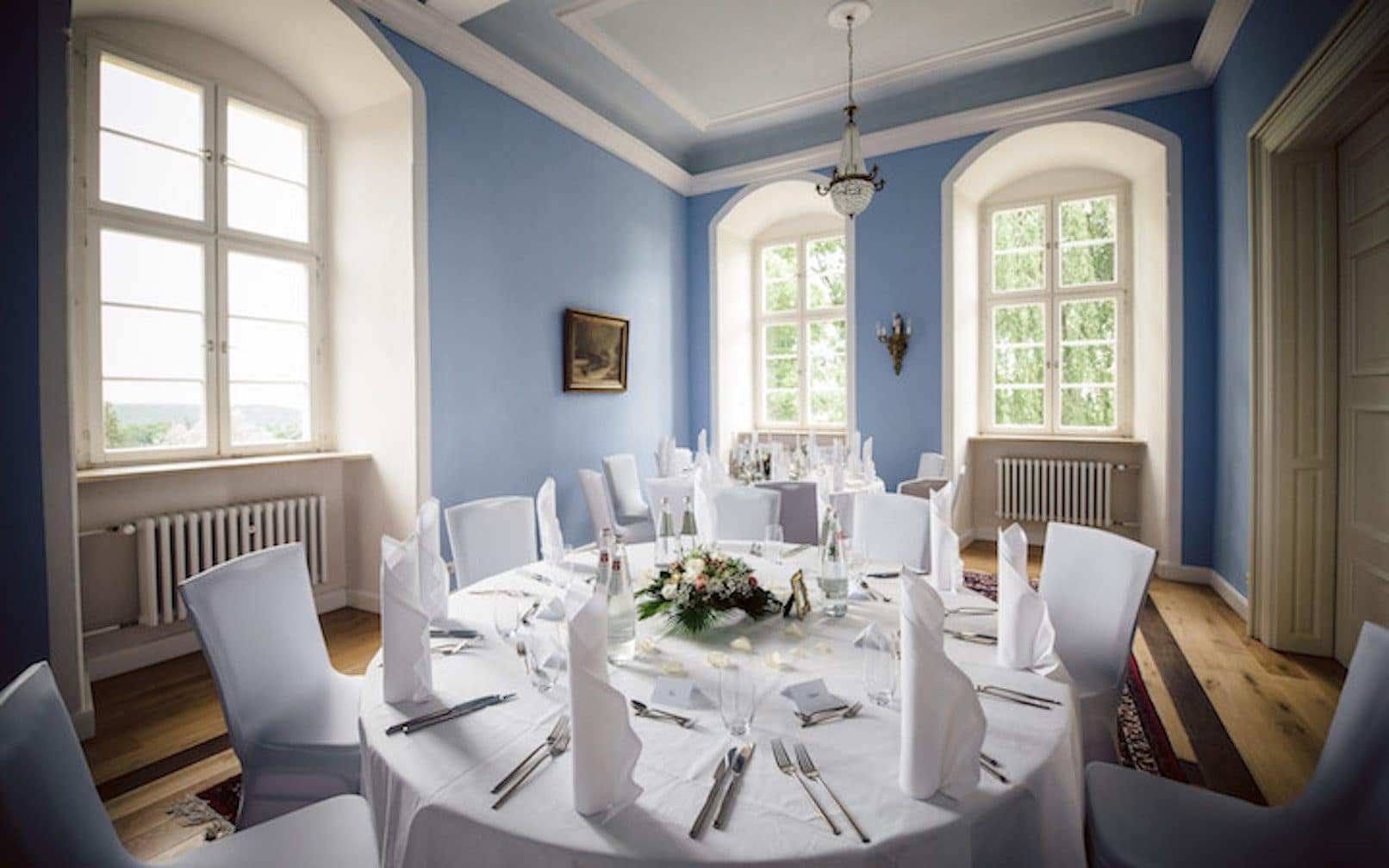Gedeckter Hochzeitstisch im Brautzimmer. Blaue Wände zeichnen sich im Brautzimmer aus.