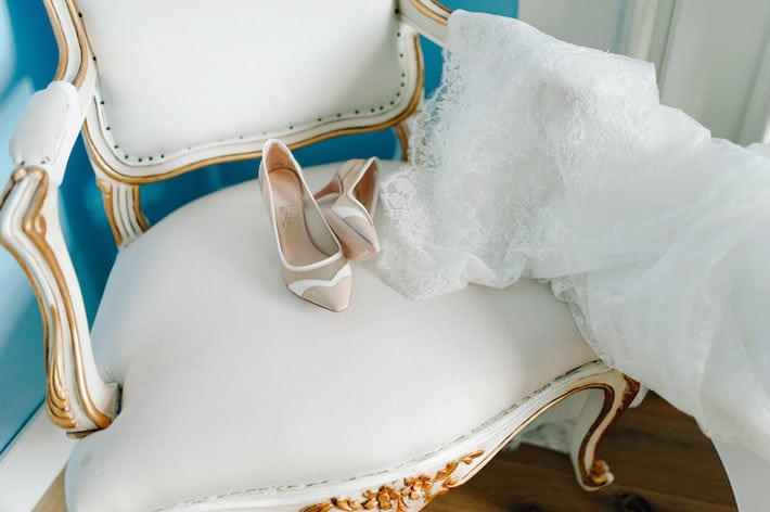 Ein Ausschnitt aus dem Brautzimmer. Auf einem Sessel liegen Hochzeitsschuhe und Schleier bereit für die Trauung bereit.