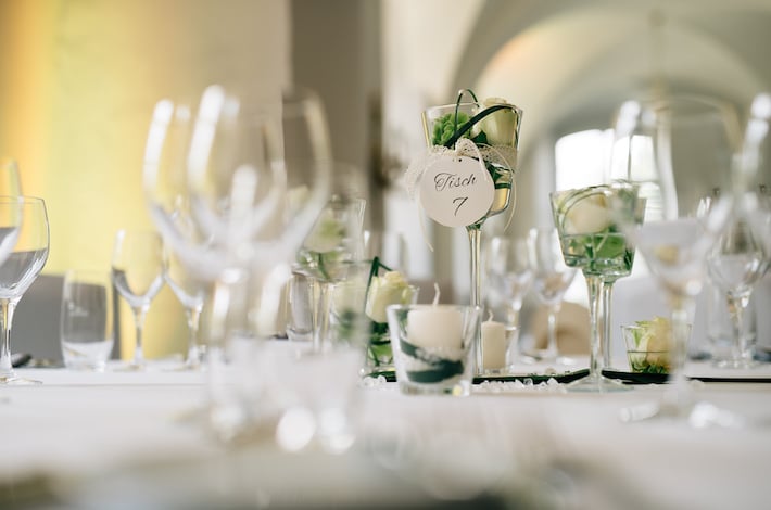 Ein gedeckter Hochzeitstisch im Schloss. Schöne Sitzplatzierungen und Tischnummerierungen zur Hochzeit.