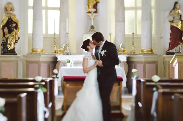 Ein Hochzeitspaar gibt sich das Ja-Wort und den Hochzeitskuss in der Schlosskapelle.