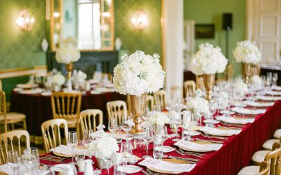 gedeckter hochzeitstisch im vintage stil mit decke aus rotem samt im schloss.