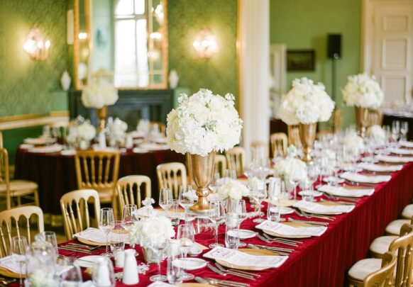gedeckter hochzeitstisch im vintage stil mit decke aus rotem samt im schloss.